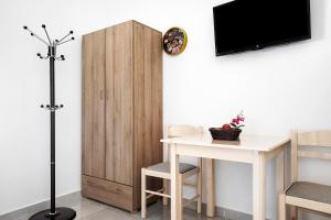 a room with a table and a tv on a wall at Iguana studio 11 in Preveza