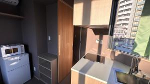 a small kitchen with a sink and a microwave at WINN hotel in Tokyo
