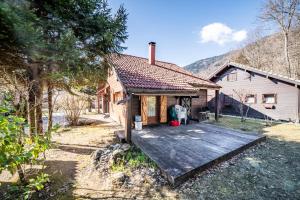 a house with a wooden deck in front of it at Chalet 7p Confort - Le refuge in Verchaix