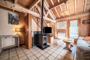 a living room with a couch and a tv at Chalet 7p Confort - Le refuge in Verchaix