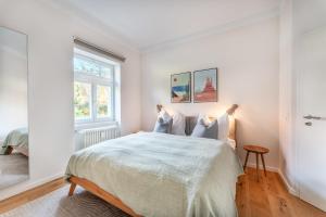 a white bedroom with a bed and a window at Ferienwohnung Waldglück in Hinterzarten +27 photos