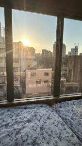 a bedroom with a view of a city from a window at WINN hotel in Tokyo