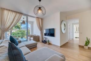 a living room with a couch and a tv at Marbella Beach San Pedro in Marbella