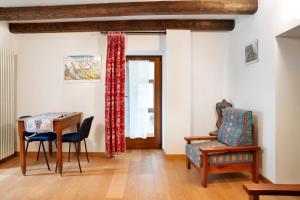 a living room with a table and a chair at Chalet Provenzale Trilocale in Acceglio