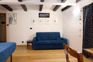 a living room with a blue couch and a table at Chalet Provenzale Trilocale in Acceglio
