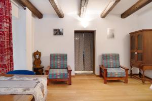 a bedroom with two chairs and a bed and a door at Chalet Provenzale Trilocale in Acceglio
