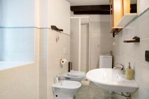 a white bathroom with a sink and a toilet at Chalet Provenzale Trilocale in Acceglio +7 photos