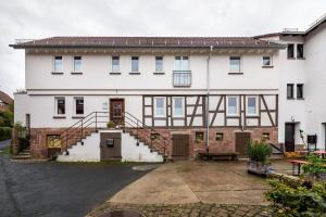 a large white house with a staircase in front of it at Sand 68 in Steinau an der Straße