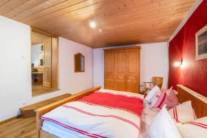 a bed in a room with a wooden ceiling at Ferienwohnung Daniel in Grainau