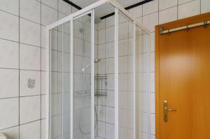 una doccia con porta in vetro in un bagno di Ferienhaus Berdum a Wittmund Altre 23 foto