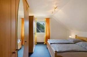 una piccola camera da letto con un letto e una finestra di Ferienhaus Berdum a Wittmund