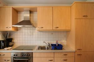 una cucina con mobili in legno e un lavello di Ferienhaus Berdum a Wittmund