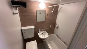 a small bathroom with a toilet and a sink at WINN hotel in Tokyo
