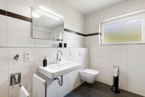 ein weißes Badezimmer mit Waschbecken und Toilette in der Unterkunft Bubach in Laubach