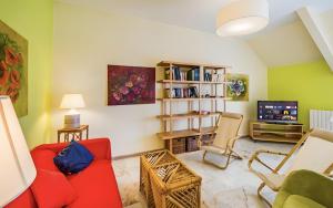 a living room with a red couch and chairs and a tv at La dimora di Alda in Lavagna