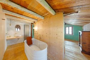 a large white tub in a bathroom with wooden walls at Cedä-M in Dosoledo +73 photos