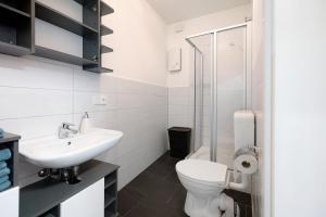 a white bathroom with a toilet and a sink at Wendelin in Sankt Wendel +11 photos