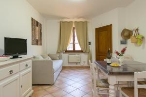 a living room with a couch and a table with a television at Podere Nuti - 4 Lauro in Cecina