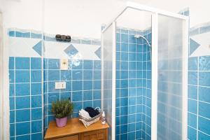 a bathroom with blue tiled walls and a shower at Casa Masala Irgoli in Irgoli +23 photos