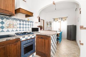 a kitchen with a stove and a refrigerator at Casa Masala Irgoli in Irgoli