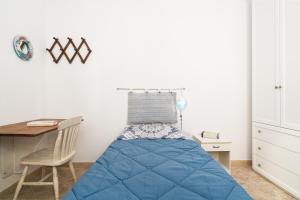 a small bedroom with a bed and a desk at Casa Masala Irgoli in Irgoli