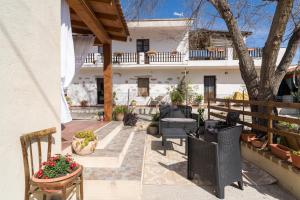 a patio with chairs and a tree and a building at Casa Masala Irgoli in Irgoli