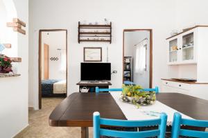 a dining room with a table and blue chairs at Casa Masala Irgoli in Irgoli