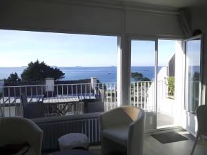 a room with a balcony with a view of the ocean at Ti Bihan - Perros Guirec in Perros-Guirec