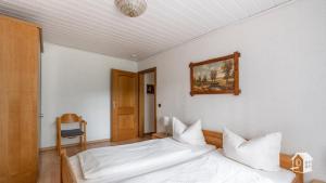 a bedroom with a bed and a picture on the wall at Ferienhaus Mengelberg in Roschbach