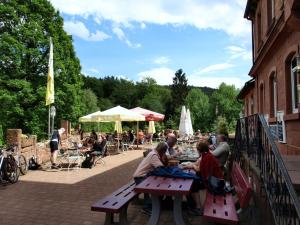 a group of people sitting at picnic tables outside a building at Ferienhaus Mengelberg in Roschbach