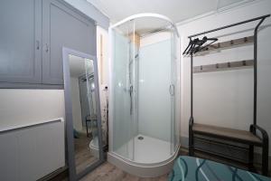 a glass shower in a bathroom with a bench at Le Gite des 3000 avec Spa in Auzat