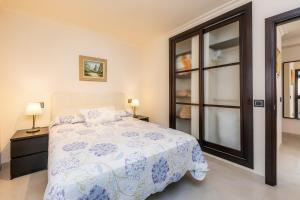 a bedroom with a bed and two lamps and a window at Gala in Cala Ratjada