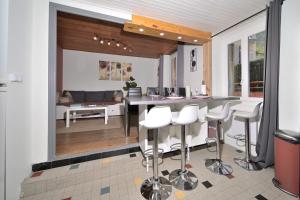 a kitchen with a bar and some white stools at Le Gite des 3000 avec Spa in Auzat +12 photos