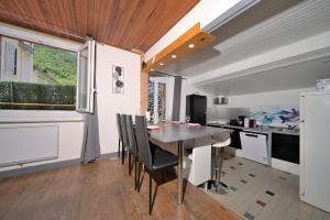 a kitchen with a dining table and a kitchen with a window at Le Gite des 3000 avec Spa in Auzat
