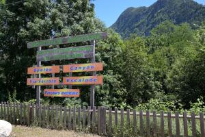 a street sign with signs in front of a fence at Le Gite des 3000 avec Spa in Auzat