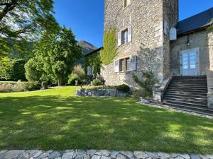 a large stone building with a grass yard at Château De La Rive in Cruet