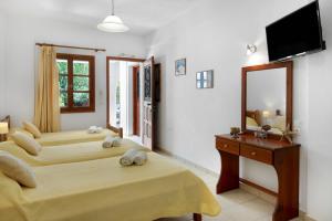 a bedroom with two beds and a mirror and a dresser at Studios Asterias 3 in Astypalaia