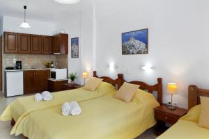 a bedroom with two beds and a kitchen at Studios Asterias 3 in Astypalaia