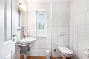 a white bathroom with a sink and a toilet at Solarferienhaus Wolkenlos in Breklum +55 photos