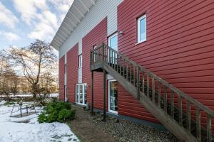 a red building with a staircase on the side of it at Solarferienhaus Wolkenlos in Breklum