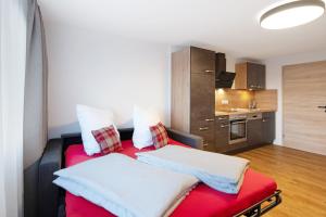 ein Wohnzimmer mit einem roten Sofa und eine Küche in der Unterkunft Kaiserchalet in Höchenschwand
