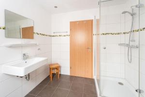 a bathroom with a sink and a shower at Am Pön - Ferienwohnungen in Medebach +32 photos