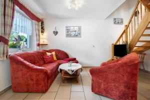a living room with two red chairs and a table at Fewo 11 - Halbinsel Darss - Ostsee in Wieck