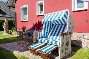 a blue and white chair sitting in front of a house at Fewo 11 - Halbinsel Darss - Ostsee in Wieck