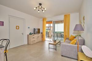 a living room with a couch and a television at New Casa Tiberio in Lazise
