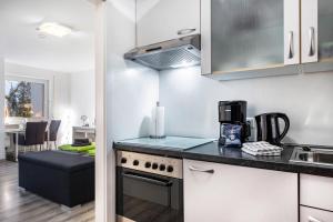 a kitchen with a stove and a counter top at Schwarzwaldblick C App 2 mit Pool in Schönwald