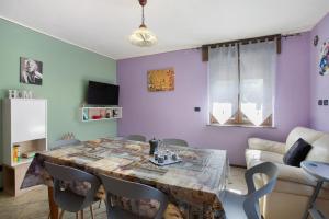 a dining room with a table with chairs and purple walls at Casa Michod Chatillon - Nonna Genia in Châtillon