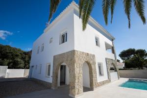 a white villa with a swimming pool at Apartamento Marei 2 in Cala Blanca