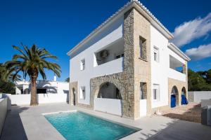 a villa with a swimming pool in front of a house at Apartamento Marei 2 in Cala Blanca