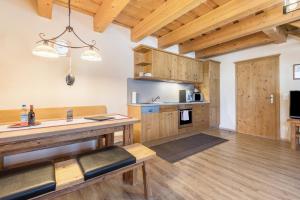a large kitchen with wooden cabinets and a table at Ferienwohnung Stod´l in Freyung